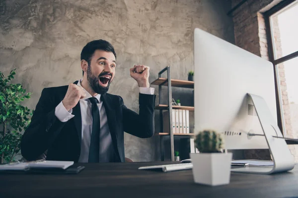 Foto de alegre hombre de negocios asombrado mirada pantalla pc levantar los puños grito desgaste traje camisa corbata en la oficina moderna en interiores —  Fotos de Stock