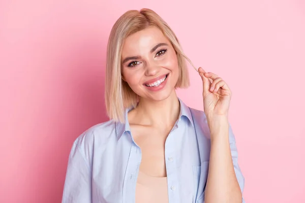 Fénykép a lenyűgöző szép csinos fiatal nő tartani haj mosoly arc elszigetelt pasztell rózsaszín háttér — Stock Fotó