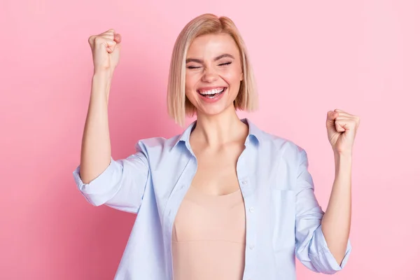 Foto de atraente jovem positivo senhora levantar punhos vencedor sorte campeão isolado no fundo cor-de-rosa — Fotografia de Stock