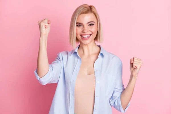 Fénykép vidám boldog fiatal nő emelje fel a kezét ököl győztes mosoly elszigetelt rózsaszín színű háttér — Stock Fotó