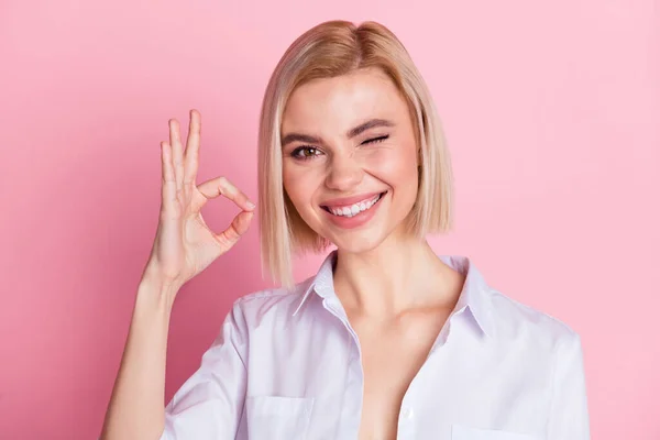 Foto van vrolijke positieve jonge charmante vrouw maken oke teken knipoog geïsoleerd op roze kleur achtergrond — Stockfoto