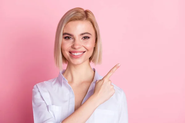 Foto de adorável jovem feliz apontar o dedo espaço vazio recomendo anúncio isolado no fundo cor-de-rosa — Fotografia de Stock