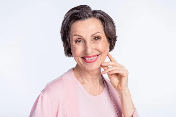 Фото пожилой привлекательной женщины счастливая положительная зубастая улыбка рука касание щеки изолированы на сером фоне цвета — стоковое фото