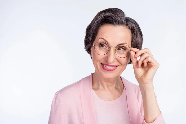 Bild av ganska charmig ålder kvinna klädd rosa outfit arm glasögon ler ser tomt utrymme isolerad vit färg bakgrund — Stockfoto