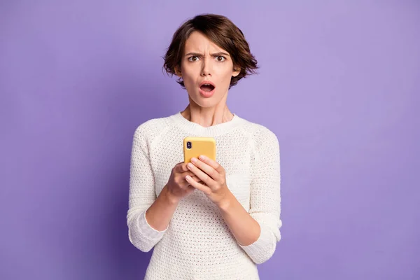 Foto portret van boos misverstand vrouwelijke student het lezen van nep nieuws mobiele telefoon geïsoleerd op heldere paarse kleur achtergrond — Stockfoto