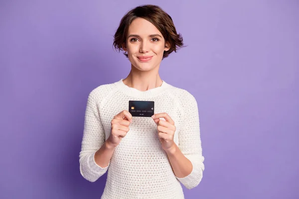 Foto retrato de alegre morena femenina tiene tarjeta de crédito bancaria sonriendo aislado en vibrante color violeta fondo —  Fotos de Stock