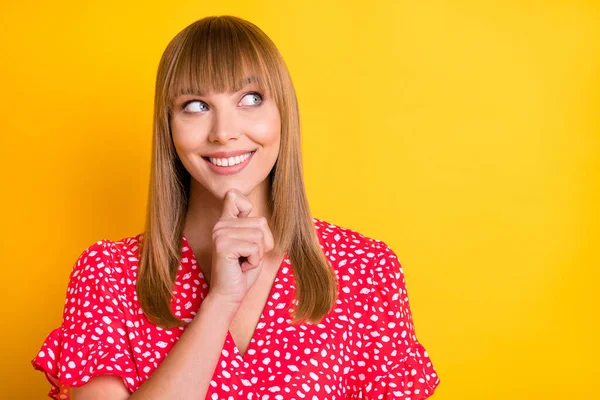 Foto de la joven encantadora de ensueño usar ropa roja brazo barbilla buscando espacio vacío aislado color amarillo fondo —  Fotos de Stock