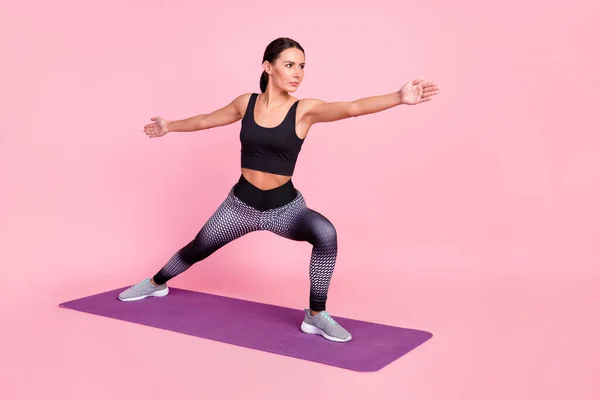 Foto de brillante encantadora joven ropa deportiva haciendo ejercicios manos brazos lados aislados color rosa fondo —  Fotos de Stock