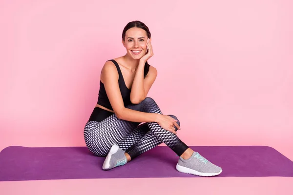 Foto de tamaño completo de la joven deportista feliz sonrisa sentarse alfombra descanso yoga refresco aislado sobre fondo de color rosa —  Fotos de Stock