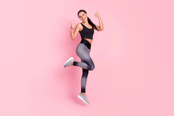 Foto de cuerpo completo de la joven mujer deportiva feliz sonrisa positiva saltar mostrar pulgar hacia arriba como fresco aislado sobre fondo de color pastel —  Fotos de Stock