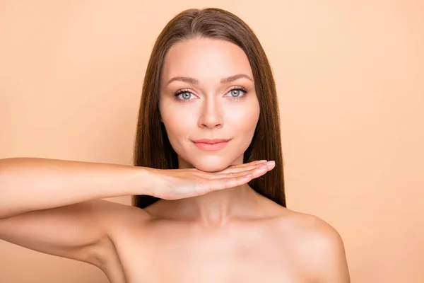 Foto de joven atractiva mano de niña bajo barbilla corrección de elevación cirugía plástica aislada sobre fondo de color beige — Foto de Stock
