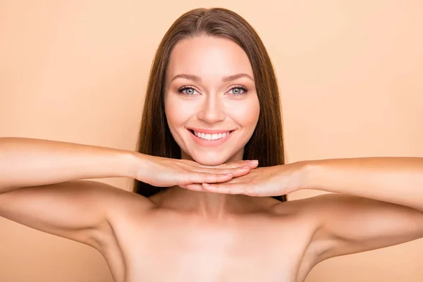 Foto de chica atractiva joven feliz sonrisa positiva manos bajo la barbilla terapia de spa procedimiento de colágeno aislado sobre fondo de color beige —  Fotos de Stock