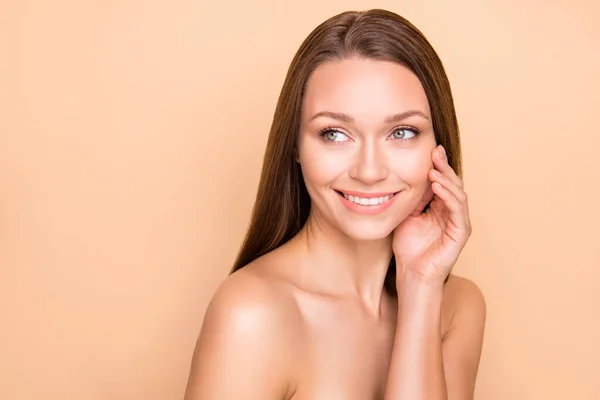 Foto de perfil de adorable señora brazo toque mejilla mirada espacio vacío sonrisa sin ropa aislada sobre fondo de color beige — Foto de Stock