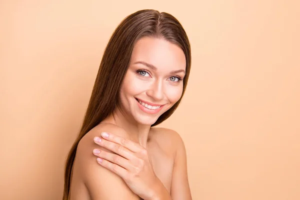 Foto de perfil de mano bonita dama tocando hombro aplicando cosmética sin ropa aislada sobre fondo de color beige — Foto de Stock