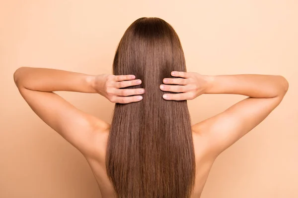 Photo arrière des bras de la jeune personne toucher parfait cheveux longs en bonne santé ne portent rien isolé sur fond de couleur beige — Photo