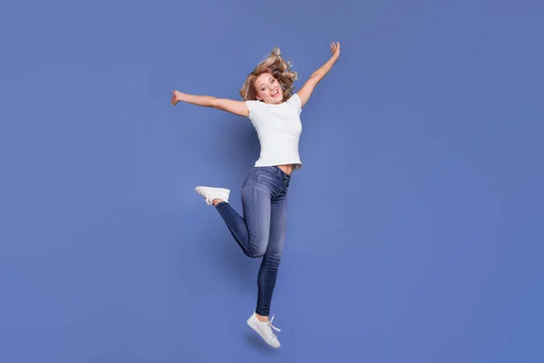 Longitud completa vista del tamaño del cuerpo de la atractiva chica de pelo ondulado alegre saltando divertirse aislado sobre fondo de color azul — Foto de Stock