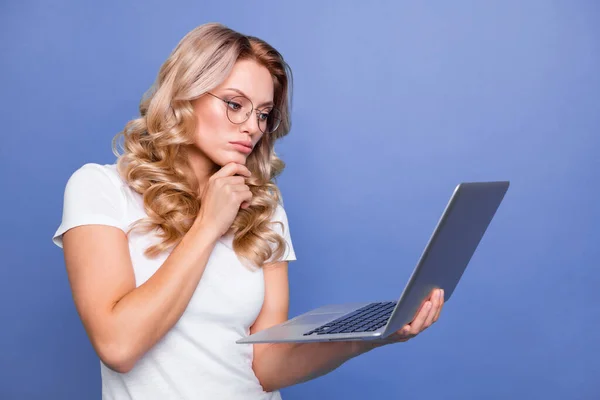 Portrait of attractive focused wavy-haired girl holding in hands laptop reading e-mail isolated over blue pastel color background — Stock Photo, Image