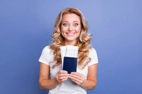 Retrato de chica atractiva alegre alegre chica de pelo ondulado sosteniendo en la mano pase boletos aéreos aislados sobre fondo de color azul — Foto de Stock