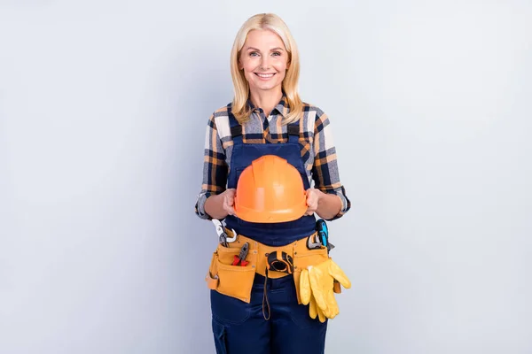 Photo of good mood shiny age crafts lady dressed blue uniform holding helmet smiling isolated grey color background — Stock Photo, Image