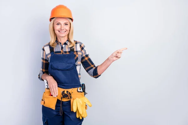 Photo of beauty cheerful blond hair lady point empty space wear cap shirt overall isolated on grey color background — Stock Photo, Image