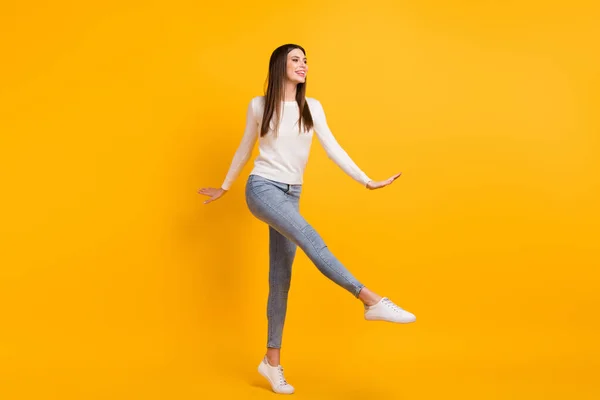 Фотографія повного розміру оптимістичної дівчини танцювальний светр джинси кросівки ізольовані на жовтому кольорі — стокове фото