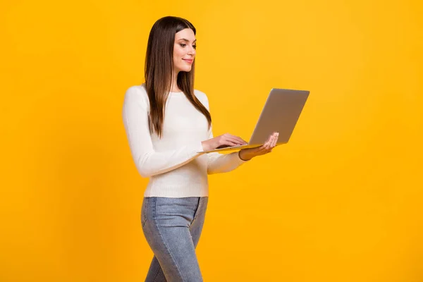 Profilo foto di ottimista ragazza bruna scrivere laptop indossare jeans maglione bianco isolato su sfondo di colore giallo — Foto Stock