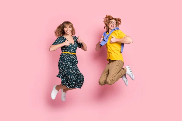 Teljes méretű profil fotó optimista vicces pár ugrás mutasd hüvelykujj fel viselni színes ruhák elszigetelt pasztell rózsaszín háttér — Stock Fotó
