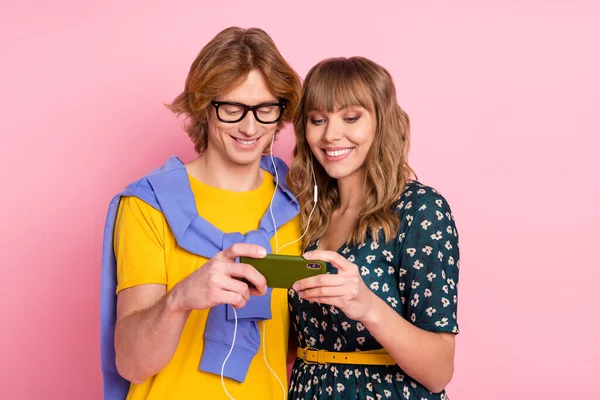 Foto di ottimista bella coppia guardare video indossare vestiti colorati isolati su sfondo rosa pastello — Foto Stock