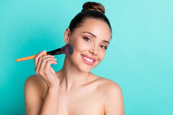 Portrait of attractive trendy cheerful girl using brush applying cc tone cream base isolated over bright teal turquoise color background — Stock Photo, Image