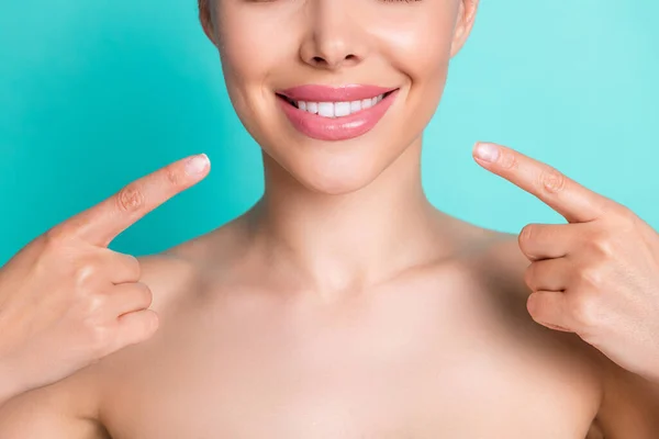 Gesneden foto van jonge vrolijke lachende vrouw dragen geen kleren wijzen vinger naar nieuwe tanden geïsoleerd op turquoise kleur achtergrond — Stockfoto