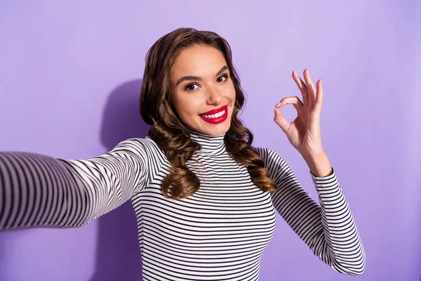 Photo of charming pretty young lady dressed striped clothes takking selfie pokazujące okey odizolowany fioletowy kolor tła — Zdjęcie stockowe