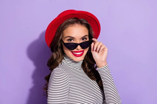 Sevimli genç bir bayanın fotoğrafı çizgili bir başlık giyiyor koyu renk göz giysisi izole edilmiş menekşe rengi arka plan — Stok fotoğraf
