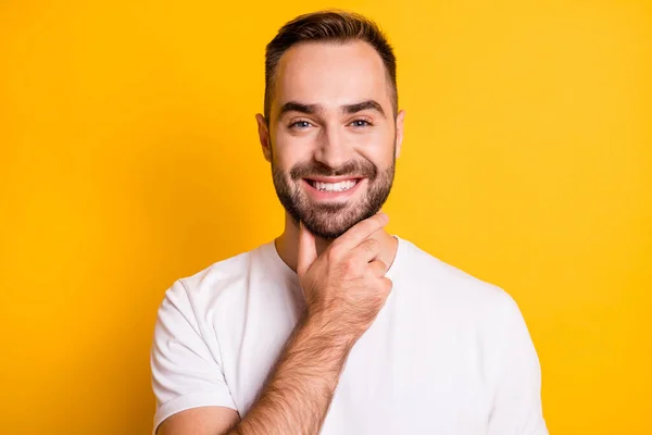 Portrait of optimistic guy hand chin wear white t-shirt isolated on vibrant yellow color background — Stock Photo, Image