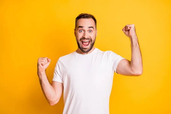 Портрет привлекательного счастливого веселого бородатого парня, празднующего удачу на ярко-желтом фоне — стоковое фото