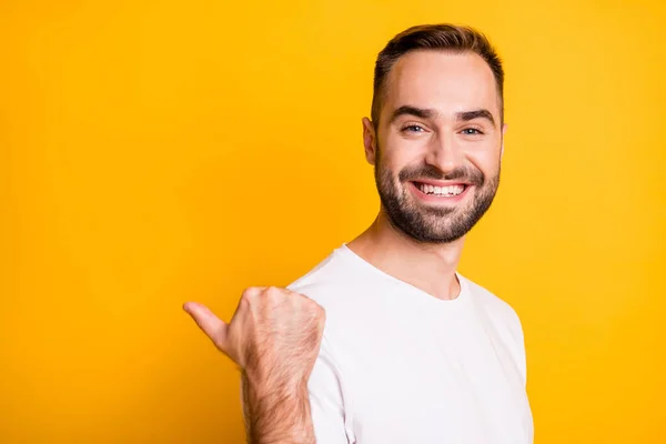 Perfil retrato de chico fresco optimista punto atrás espacio vacío desgaste camiseta blanca aislada sobre fondo de color amarillo vibrante — Foto de Stock