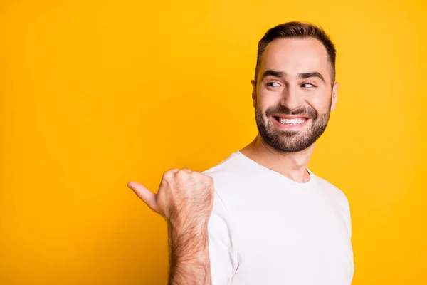 Profil Porträt des optimistischen coolen Kerls Punkt Blick zurück leeren Raum tragen weißes T-Shirt isoliert auf lebendigen gelben Hintergrund — Stockfoto