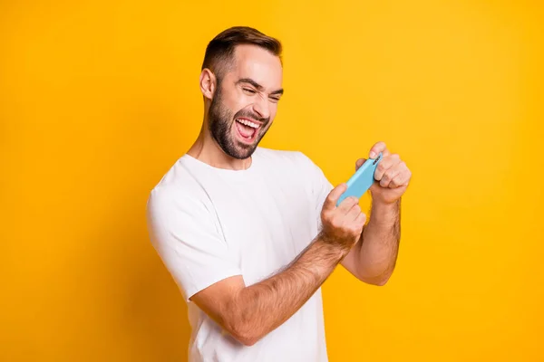 Portret van mooie verslaafde vrolijke kerel met behulp van gadget spelen netwerk spel geïsoleerd over helder gele kleur achtergrond — Stockfoto