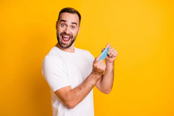 Profiel portret van onder de indruk man schieten telefoon schreeuwen dragen witte t-shirt geïsoleerd op levendige gele kleur achtergrond — Stockfoto