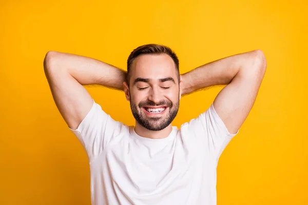 Portrét optimistického chlapa lehnout si zavřené oči nosit šedé tričko izolované na pulzujícím žlutém pozadí — Stock fotografie