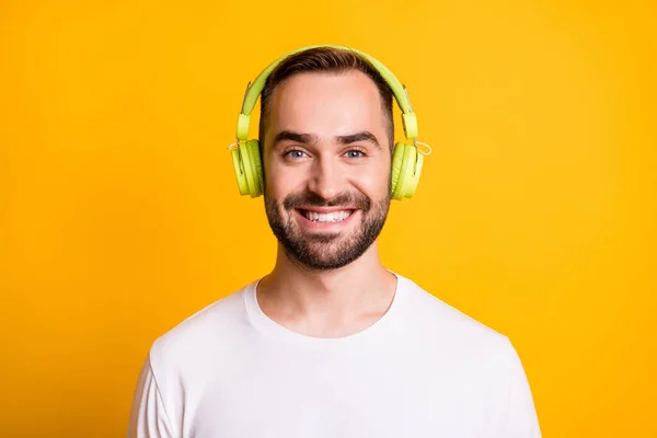 Retrato de tipo optimista escuchar música desgaste camiseta gris aislado sobre fondo de color amarillo vibrante — Foto de Stock