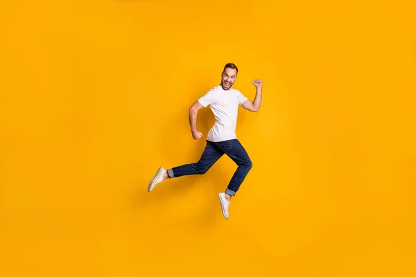 Longitud completa tamaño del cuerpo foto del hombre saltando con ropa casual aislada de color amarillo brillante fondo —  Fotos de Stock