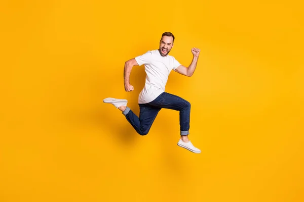 Full length body size foto van springen vrolijke mannelijke model dragen stijlvolle outfit geïsoleerde levendige gele kleur achtergrond — Stockfoto