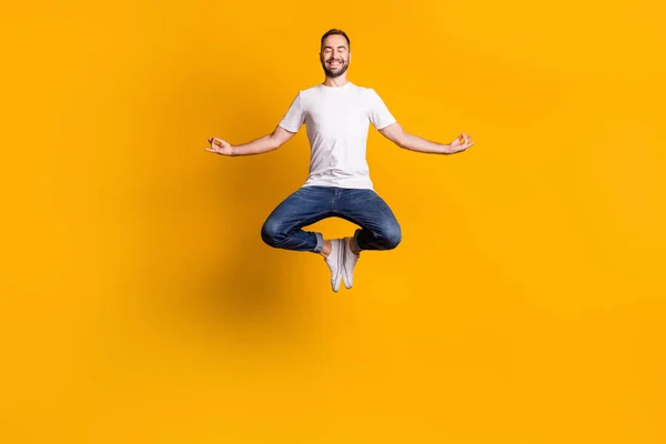 Lunghezza completa dimensioni del corpo foto di salto uomo sorridente facendo esercizi di yoga asana isolato vivido colore giallo sfondo — Foto Stock