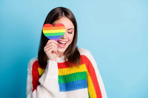 Foto de mujer joven dulce soñadora vestida a rayas suéter cubierta ojo colorido corazón sonriendo espacio vacío aislado color azul fondo — Foto de Stock