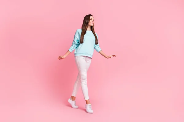 Retrato de tamaño completo de joven caminando mirada espacio vacío desgaste jersey azul claro aislado sobre fondo de color rosa —  Fotos de Stock