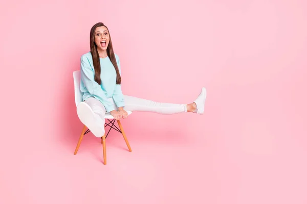Full size ritratto di persona allegra sollevare le gambe bocca aperta indossare maglione azzurro isolato su sfondo di colore rosa — Foto Stock