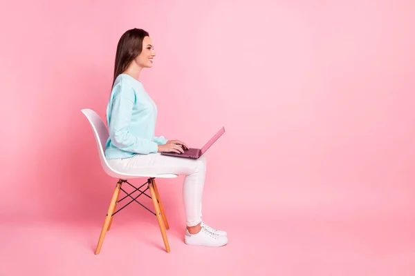 Full size profiel portret van charmante vrolijke persoon zitten gebruik laptop slijtage trui geïsoleerd op roze kleur achtergrond — Stockfoto