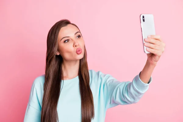 Foto de hermosa mujer joven coqueta tomar foto selfie enviar aire beso aislado en pastel de color rosa fondo — Foto de Stock