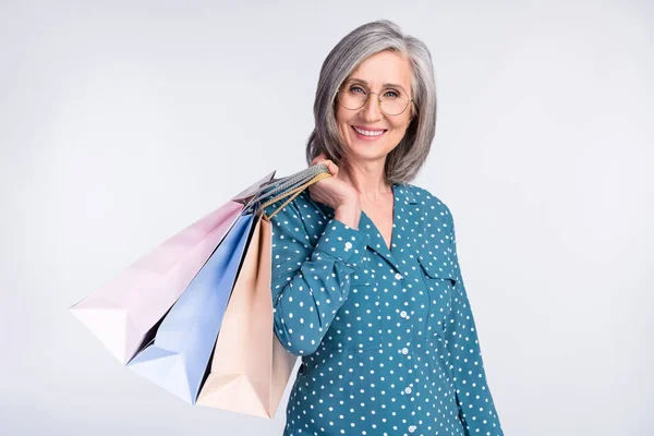 Portrait photo de femme d'affaires senior dans des lunettes gardant des sacs sur la vente shopping sourire isolé sur fond de couleur blanche — Photo