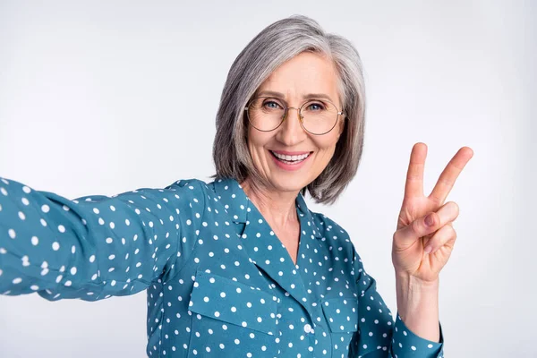 Foto porträtt av senior affärskvinna i glasögon tar selfie visar v-tecken isolerad på vit färg bakgrund — Stockfoto
